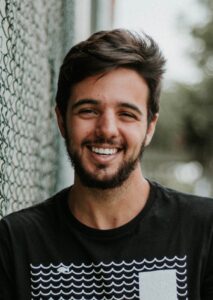 man smiling and leaning on fence