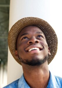 man wearing hat smiling and looking up